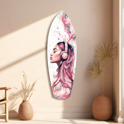 Oval glass wall art featuring a woman with pink and purple hair wearing headphones, displayed on a beige wall between two terracotta vases.