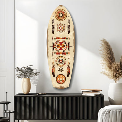 Wooden surfboard-shaped wall art with red, orange, and brown Aztec geometric patterns displayed above black cabinet in minimalist room setting.