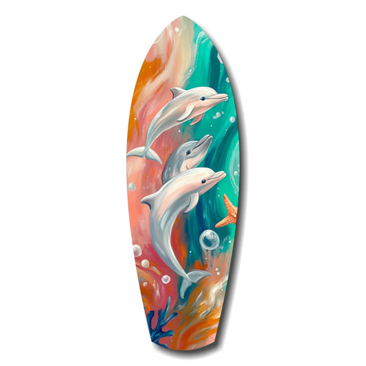 Surfboard-shaped glass art featuring three dolphins swimming among colorful coral and bubbles in turquoise, orange, and pink tones.