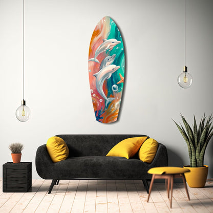 Colorful glass surfboard wall art depicting three leaping dolphins in turquoise and coral tones, displayed above a black sofa in a modern living room interior.
