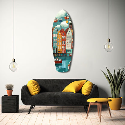 Vertical oval glass wall art displaying colorful coastal buildings, boats, and hot air balloons, hung above a black sofa with yellow pillows in a modern living room.