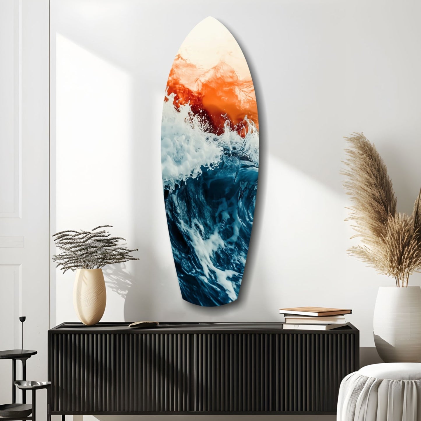 Surfboard-shaped glass wall art displaying orange sunset gradients transitioning to deep blue ocean waves, mounted above a black ribbed console table.