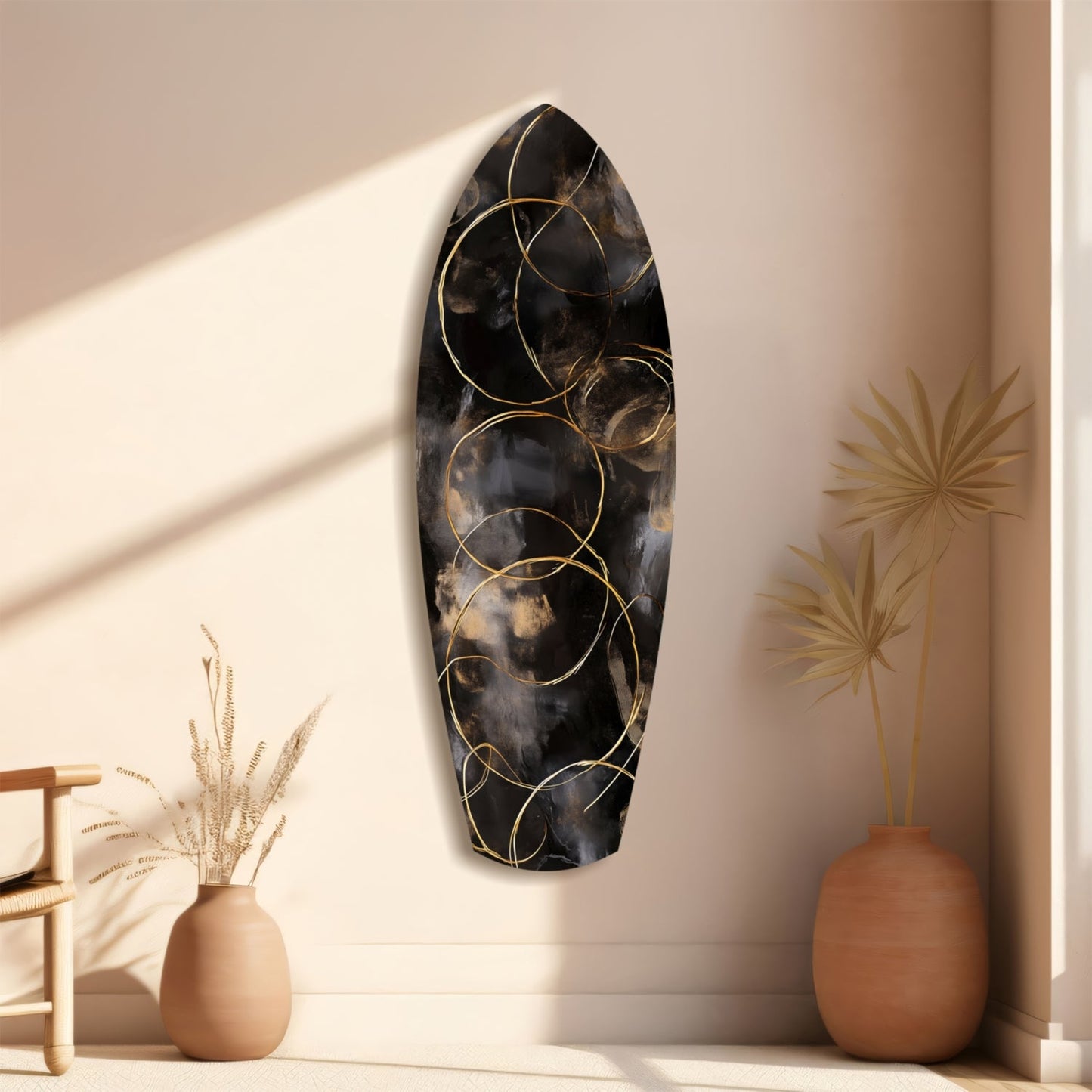 Black glass wall art with gold circular patterns displayed on beige wall between terracotta vases with dried botanicals.