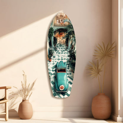 Vintage surfboard-shaped glass wall art featuring a turquoise 1950s convertible car on checkered floor, displayed on beige wall with decorative vases.