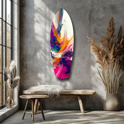 Colorful abstract paint splatter glass art hanging on gray wall above wooden bench in minimalist room with dried flowers.