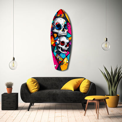 Colorful stacked skull glass wall art in vibrant geometric patterns displayed above a black sofa in a modern living room setting.