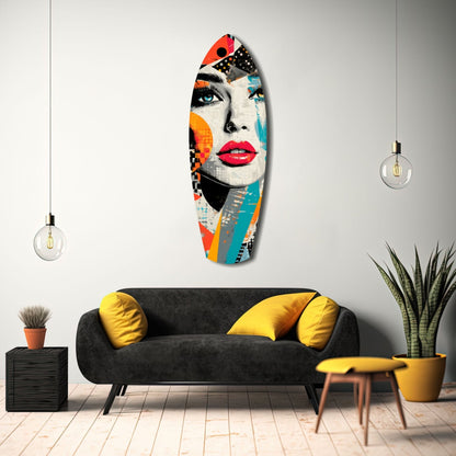 Colorful pop art glass wall sculpture featuring a woman's face with bold red lips, orange and teal geometric patterns, displayed above a black sofa with yellow pillows.