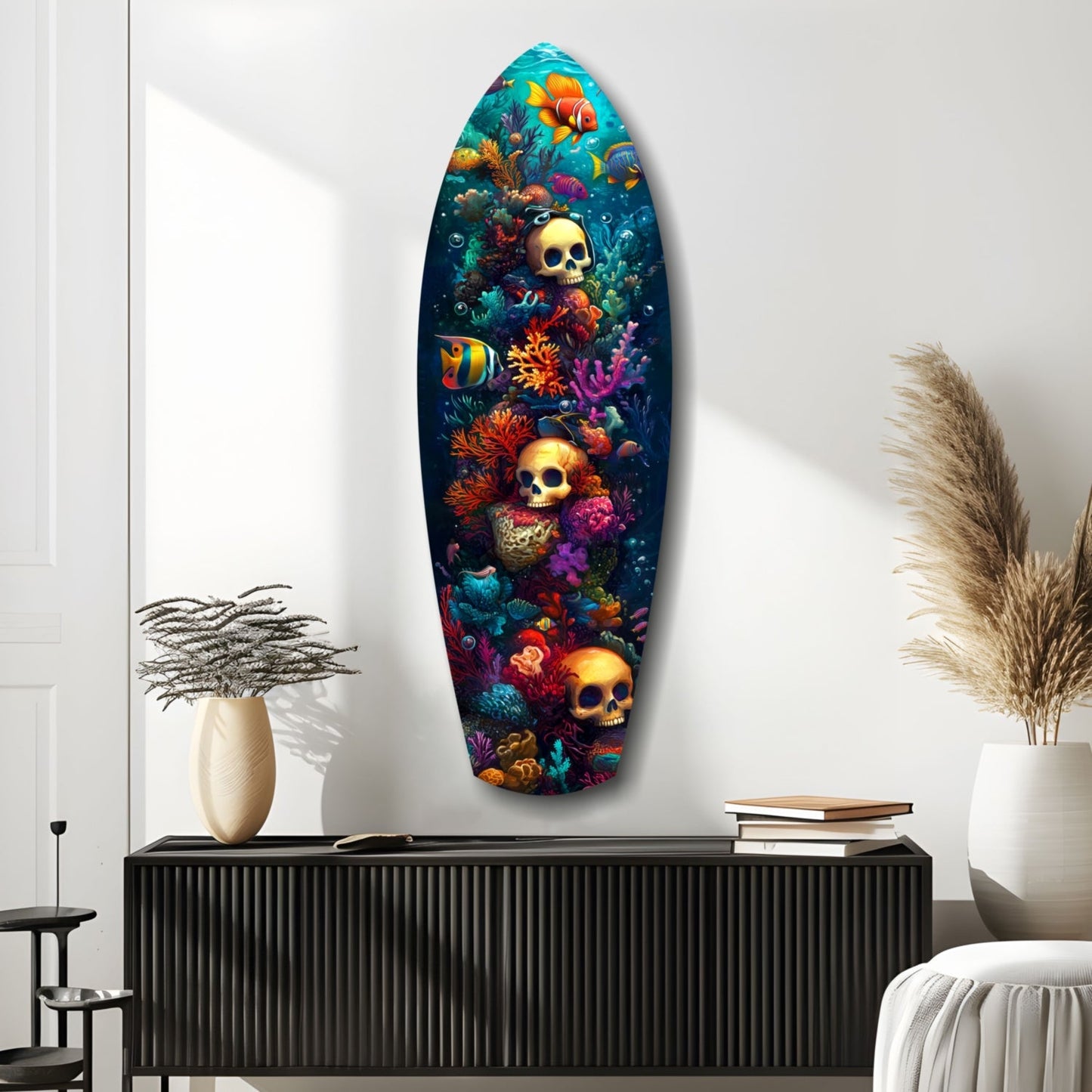 Surfboard-shaped glass wall art displaying golden skulls among vibrant coral, tropical fish, and sea life on dark blue background, mounted in modern white room.