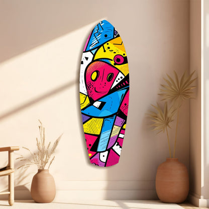 Colorful geometric glass wall art with pink face and blue, yellow, magenta sections displayed on beige wall beside decorative vases.