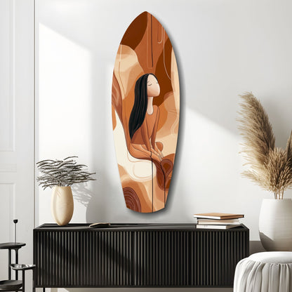 Oval glass wall art depicting a woman with long black hair in warm earth tones, displayed above a black ribbed cabinet in a minimalist interior.