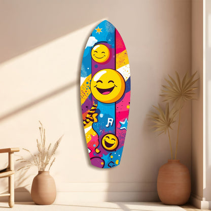 Colorful smiley face glass wall art hanging on beige wall between two terracotta vases with dried plants.
