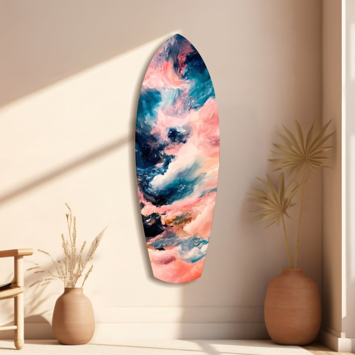 Elongated oval glass wall art with pink, teal, and white abstract cloud patterns displayed between terracotta vases and dried grasses.