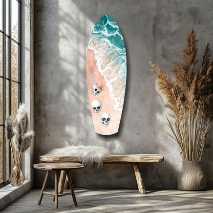 Surfboard-shaped glass wall art displaying ocean waves and three skull designs mounted above a wooden bench in a minimalist interior.