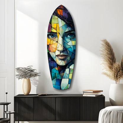 Colorful stained glass wall art featuring a fragmented face with blue eyes and multicolored geometric panels displayed above a black cabinet.