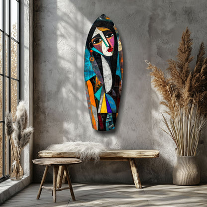 Cubist Muse Glass Wall Art displayed on gray wall above wooden bench, showing colorful abstract female face with geometric shapes in vibrant blues, oranges, and reds.