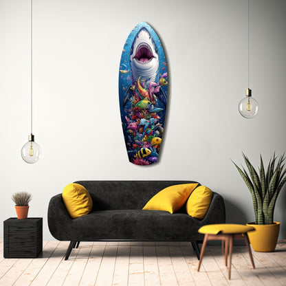 Shark with open mouth and colorful coral reef scene mounted on white wall above black sofa with yellow pillows.