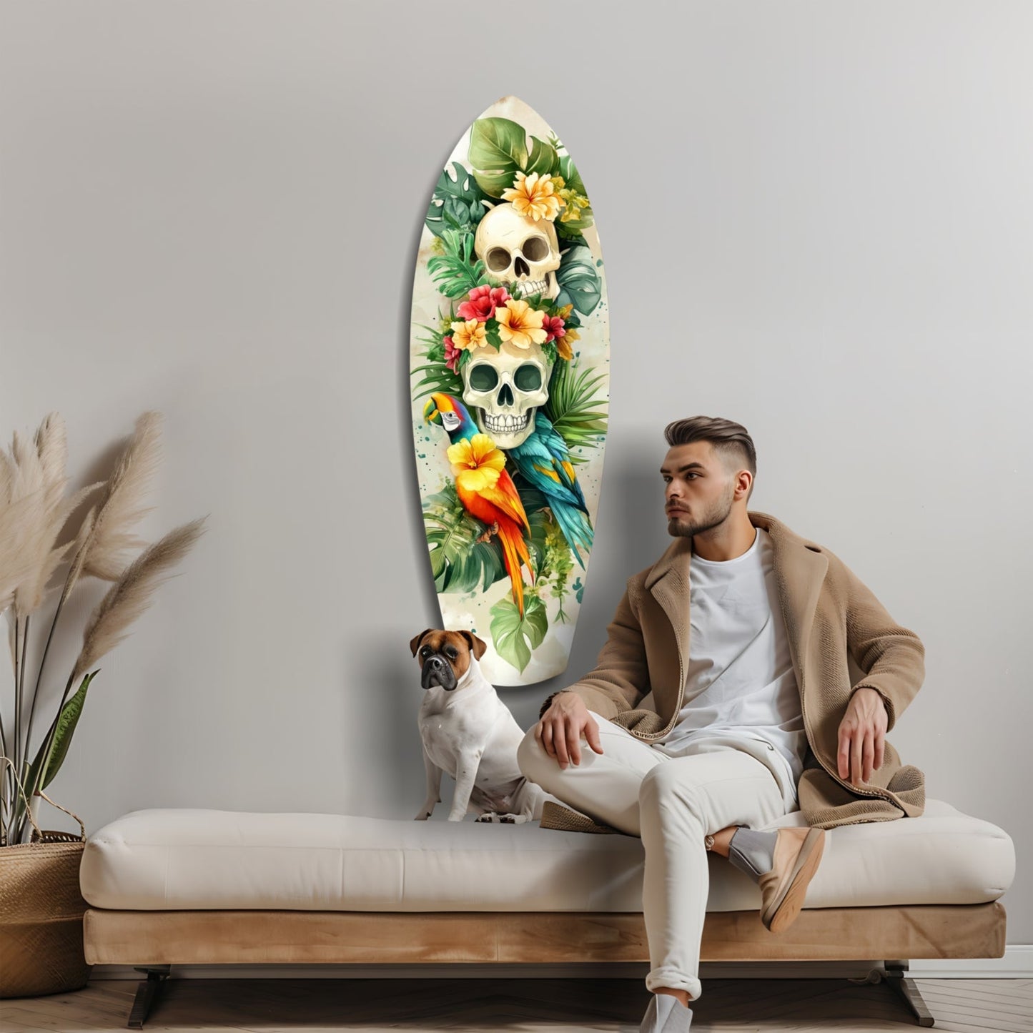 Man with dog sitting on bench beside elongated oval glass wall art featuring two skulls with colorful flowers, tropical leaves, and a parrot.