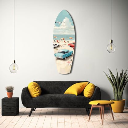 Surfboard-shaped glass wall art depicting vintage beach scene with blue car, umbrellas, and ocean, displayed above black sofa with yellow pillows.