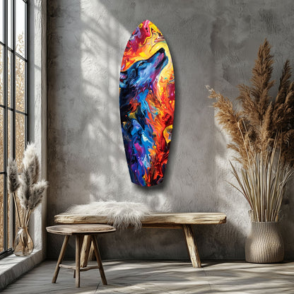 Colorful abstract glass surfboard art with red, yellow, blue, and purple swirled patterns displayed on gray wall above wooden bench.