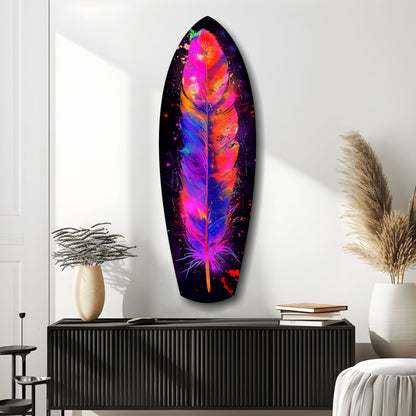 Vibrant neon feather glass art in pink, orange, and blue mounted on white wall above black cabinet with decorative items.