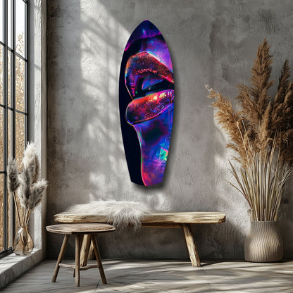 Neon lips glass wall art in vibrant purple, red, and blue displayed on concrete wall beside wooden bench and dried pampas grass.
