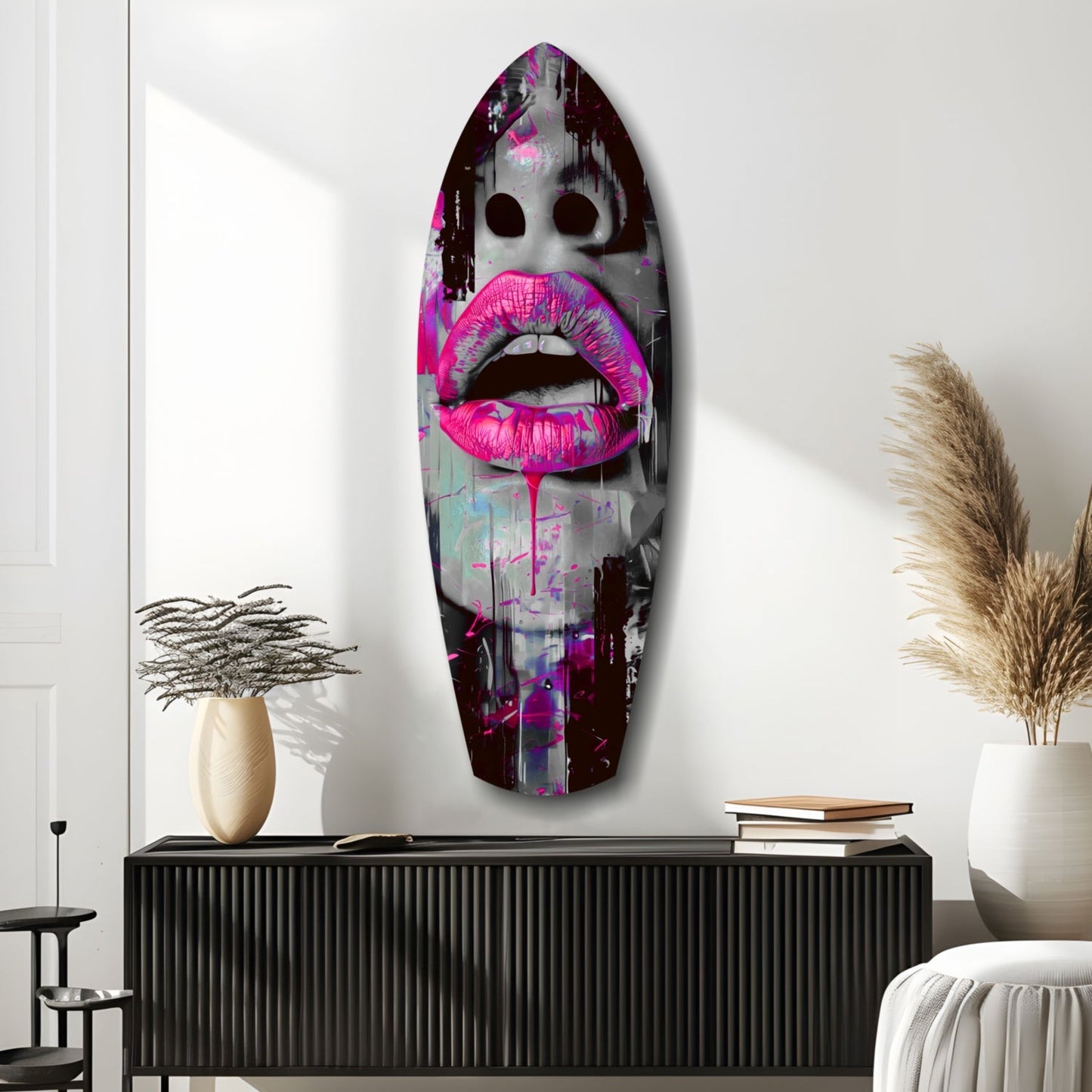 Vibrant pink lips glass wall art displayed above black credenza in modern interior with plants and books.