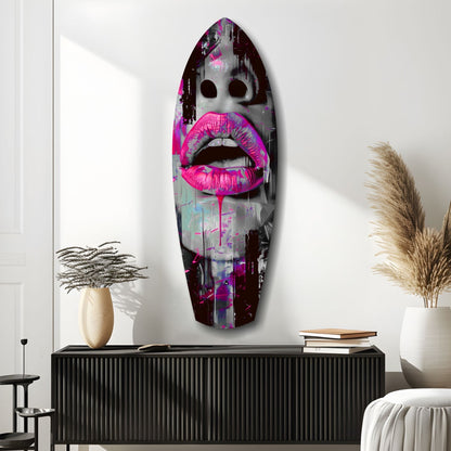 Vibrant pink lips glass wall art displayed above black credenza in modern interior with plants and books.