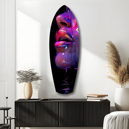 Vibrant neon lips glass art installation mounted on white wall above black console with decorative vases and books.