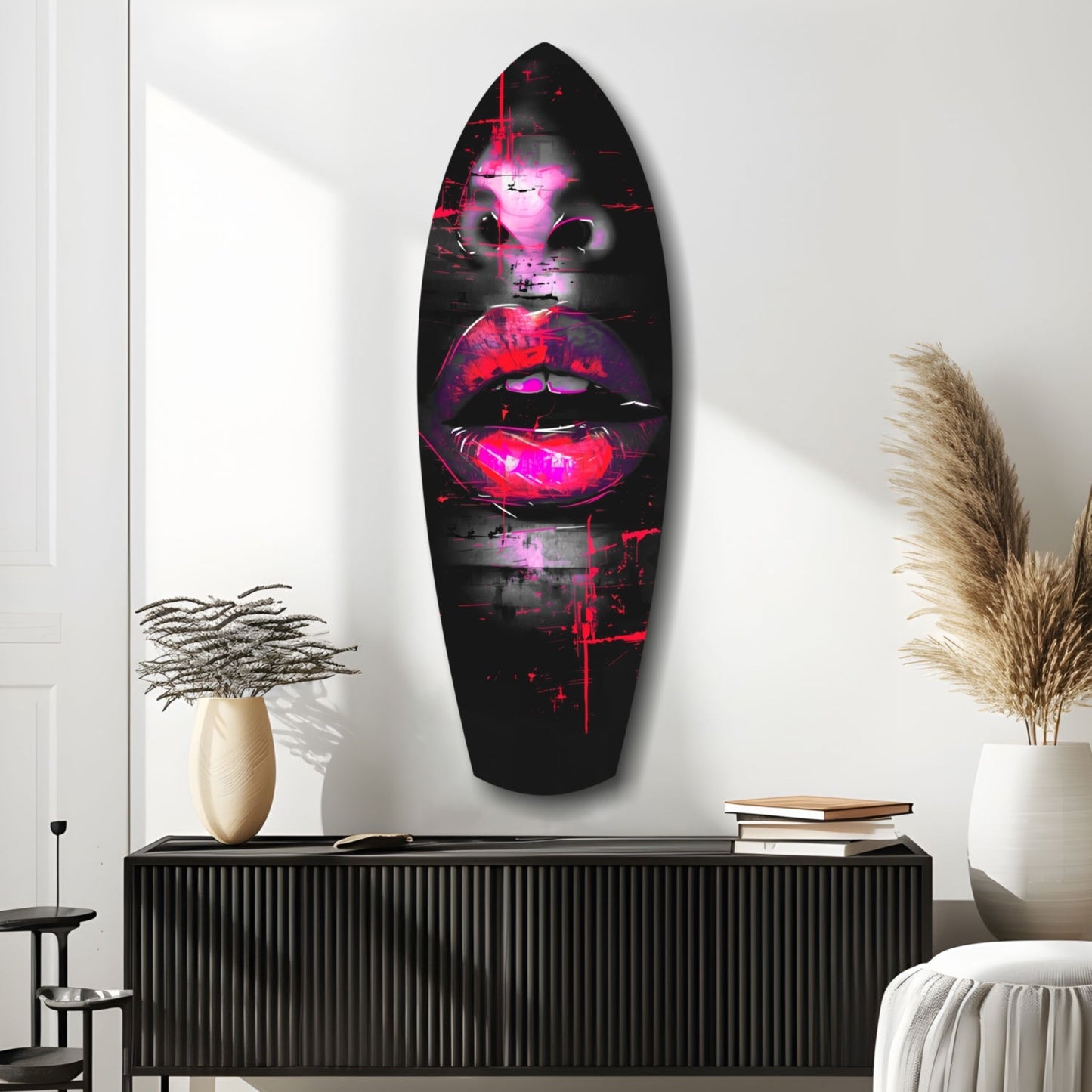 Neon pink and magenta lips glass wall art mounted above black console in modern interior with white walls and decorative vases.