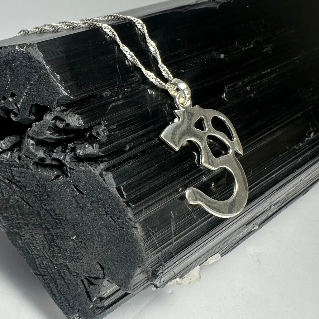 Sterling silver ohm pendant with twisted rope chain on black crystal