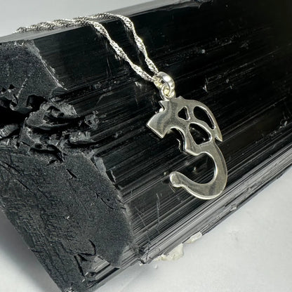 Sterling silver ohm pendant with twisted rope chain on black crystal