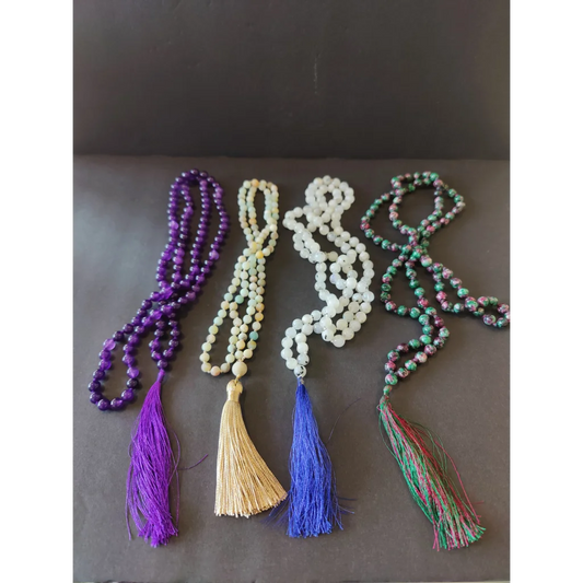 Four stone bead mala necklace strands with purple, green, white, multicolored beads