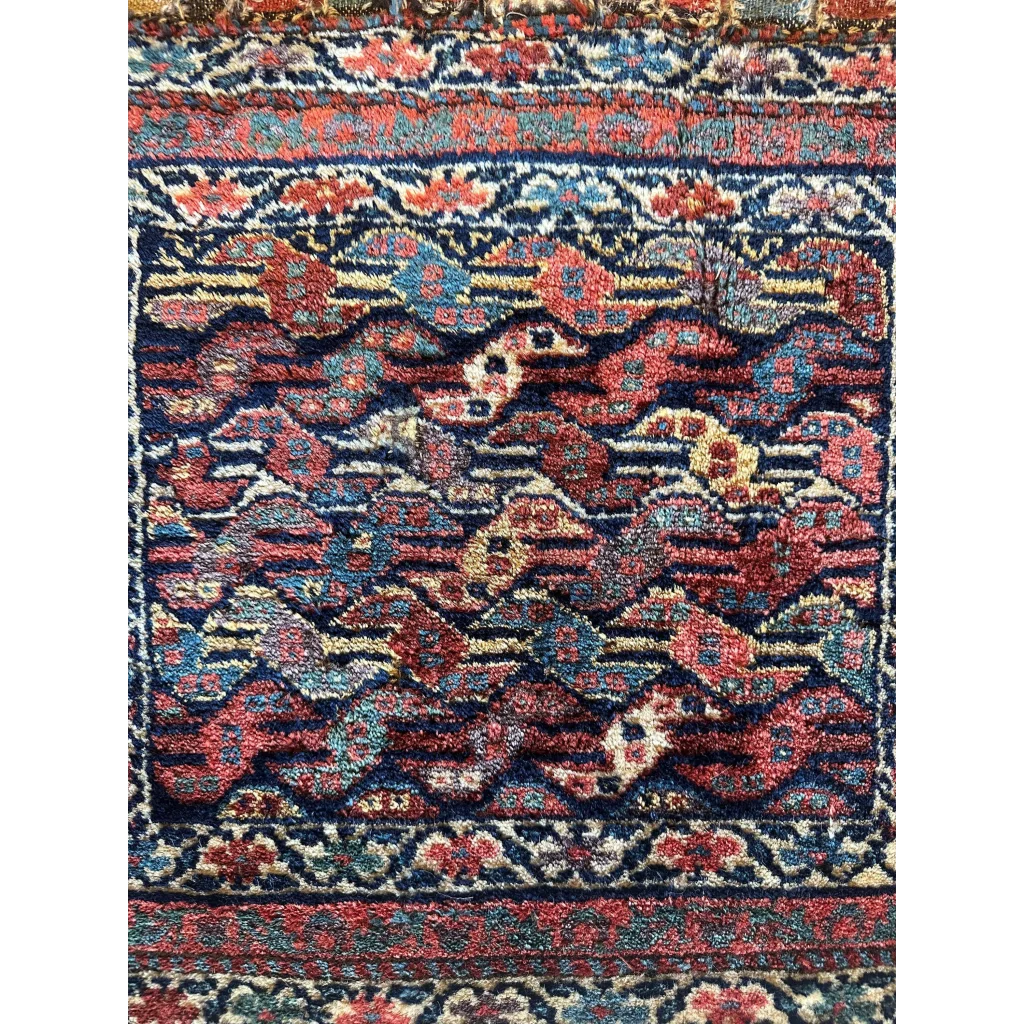 1900s Persian hanging rug, detail of intricate floral motifs in red and blue, hand-knotted wool