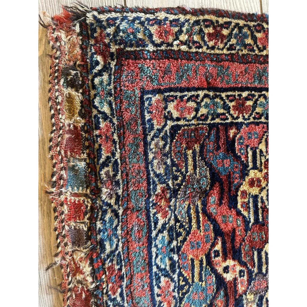 Stunning 1900s Persian hanging rug with intricate floral and geometric patterns in rich reds, deep blues, and faded gold on wool