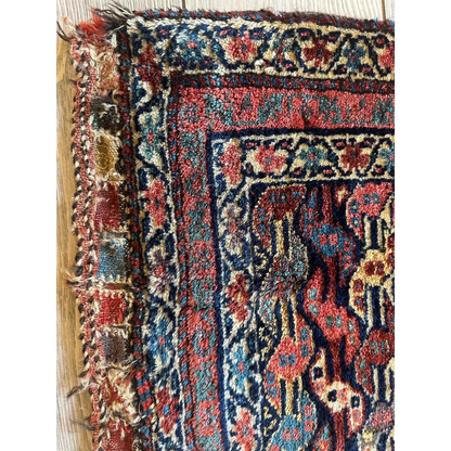 Stunning 1900s Persian hanging rug with intricate floral and geometric patterns in rich reds, deep blues, and faded gold on wool