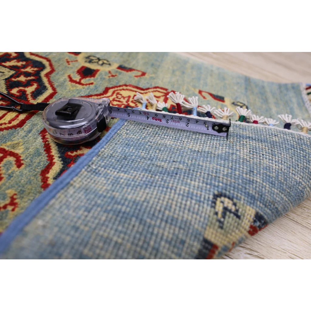 Silver tape measure on stunning Afghan Kazak runner with cotton foundation