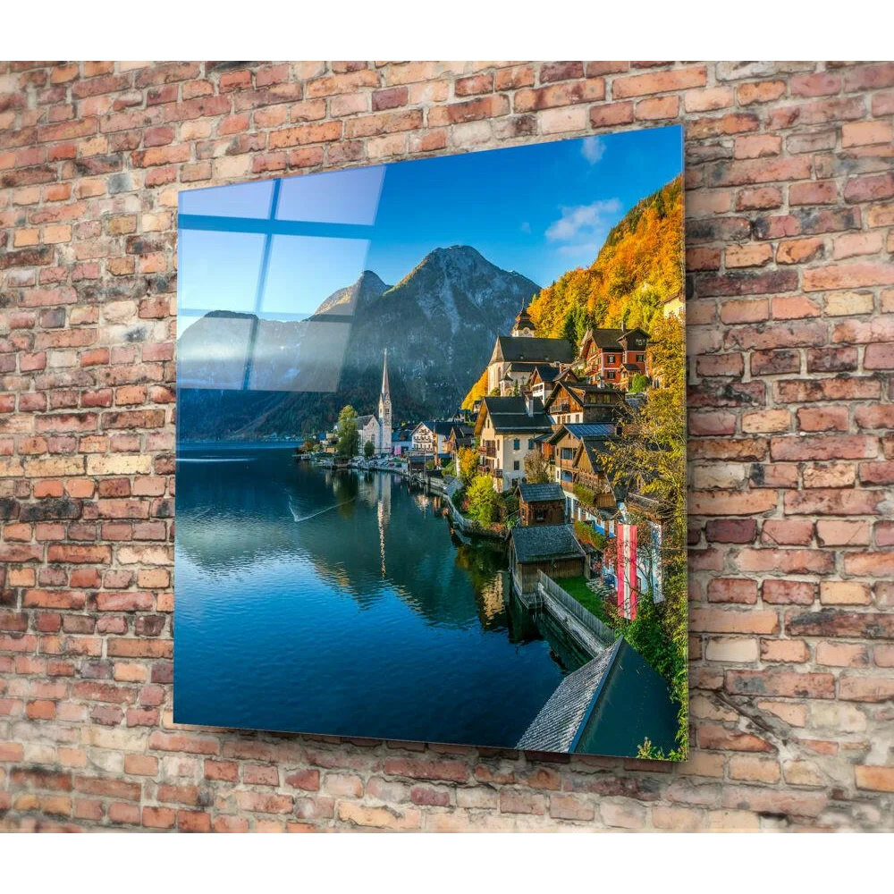 Vibrant alpine village glass wall art with mountain lake reflection