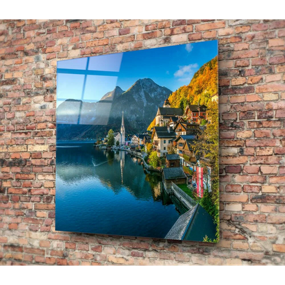 Vibrant alpine village glass wall art with mountain lake reflection