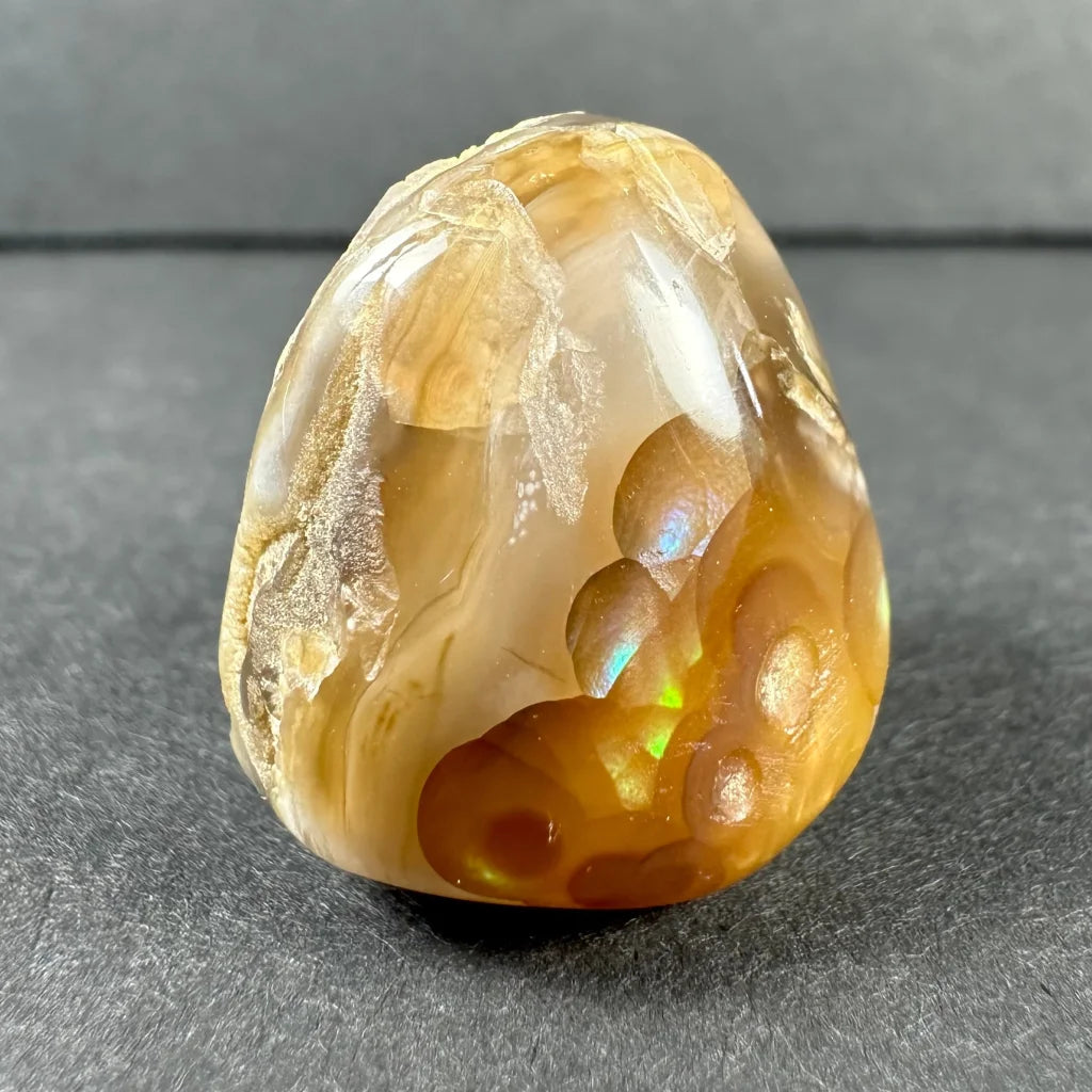 Stunning amber agate gemstone with golden swirls and iridescent bubbles