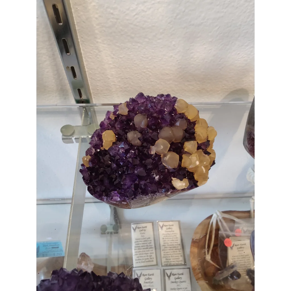 Vibrant purple amethyst geode sculpture with golden calcite inclusions