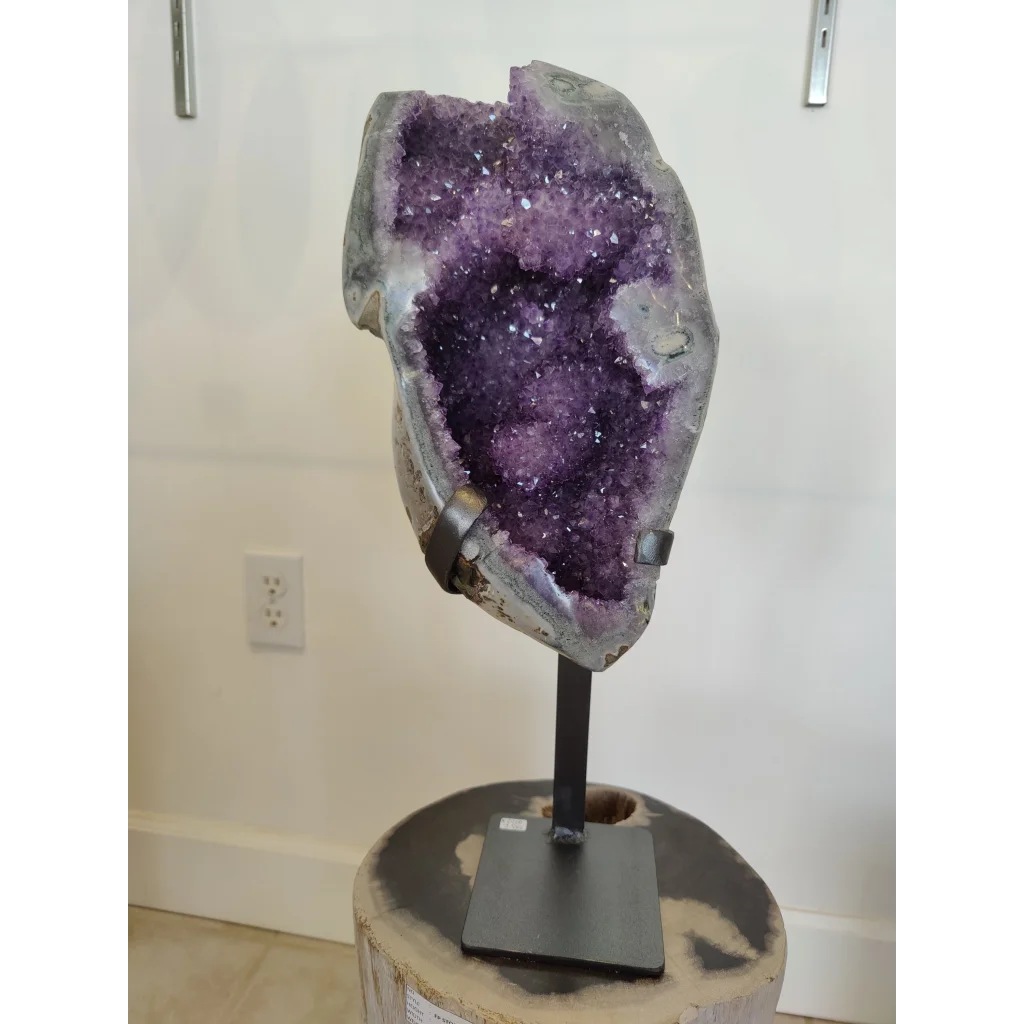 Stunning amethyst geode sculpture on wrought iron display stand