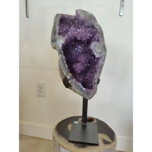 Stunning amethyst geode sculpture on wrought iron display stand