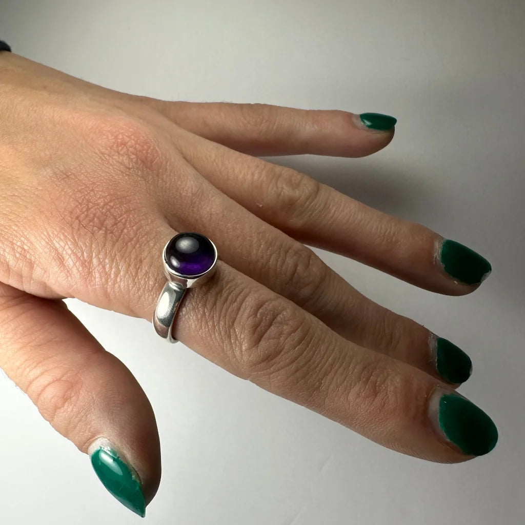 Sleek silver amethyst ring with round deep purple gem in minimalist band