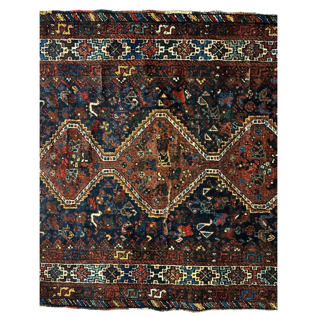 Antique 1920s Persian Khamseh rug with intricate geometric and floral patterns in deep burgundy, navy blue and gold tones on woolen weave