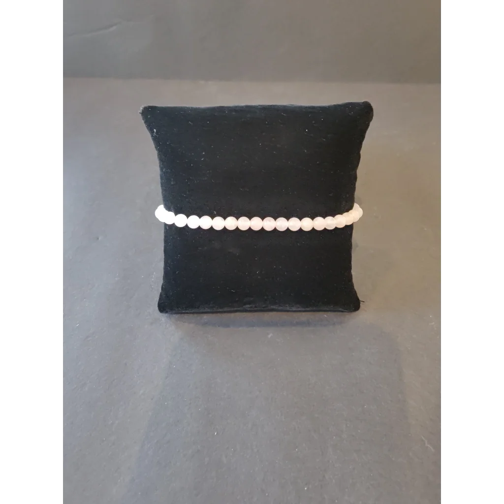 Delicate white pearl beaded stone bracelet on black velvet cushion