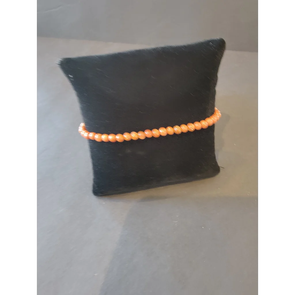 Delicate peach beaded stone bracelet 4mm on black velvet