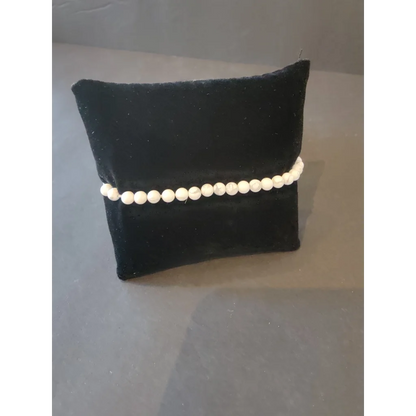Delicate white pearl beaded stone bracelet on black velvet cushion