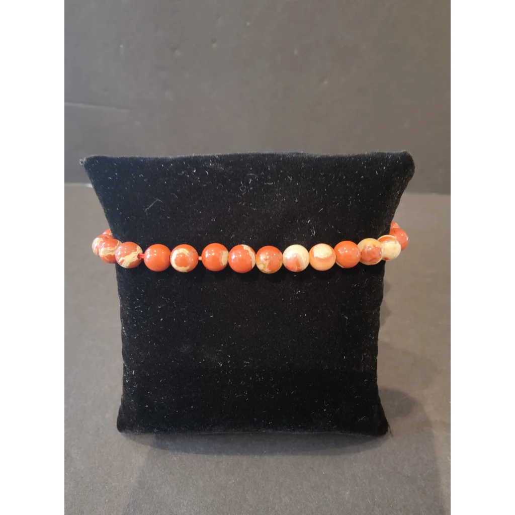 Stunning coral and cream marbled beaded stone bracelet 6mm on black velvet