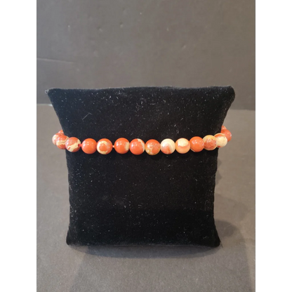 Stunning coral and cream marbled beaded stone bracelet 6mm on black velvet