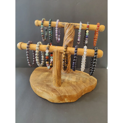 Natural wood stand displaying colorful beaded stone bracelet with 8mm gems